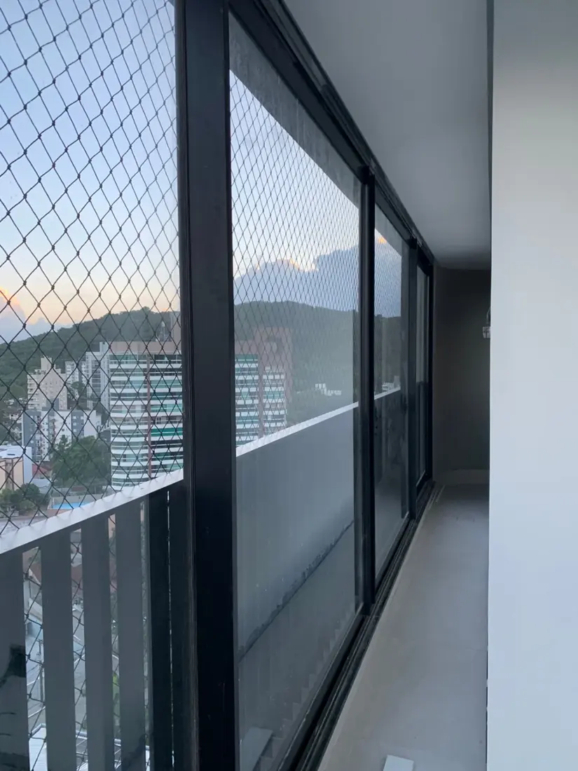 Sacada com rede de proteção e acabamento em estrutura preta instalada pela Telas SC